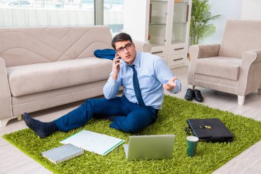 İş adamı eve iş getirip fazla mesai yapıyor.