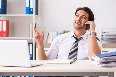 Genç yakışıklı işadamı ofiste çalışıyor.