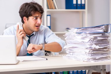 Çok fazla işi ve evrak işi olan yoğun bir çalışan.