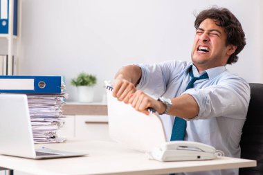Çok fazla işi ve evrak işi olan yoğun bir çalışan.