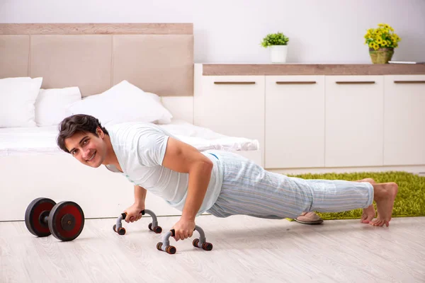 Joven haciendo rutina matutina en el dormitorio —  Fotos de Stock