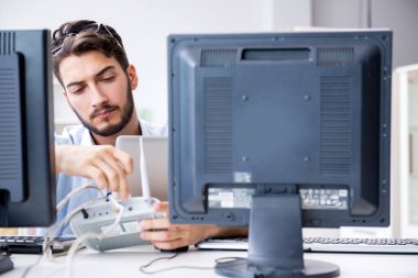 IT teknisyeni bilişim ekipmanlarına bakıyor.
