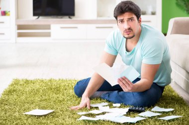 Genç adam kişisel finans ve faturalarla boğuşuyor.