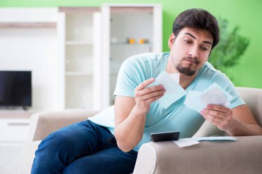 Genç adam kişisel finans ve faturalarla boğuşuyor.