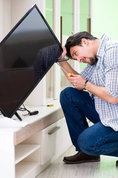 Young man husband repairing tv at home — Stock Photo, Image