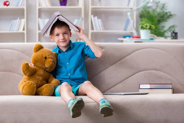 Kleine jongen die thuis boeken leest — Stockfoto
