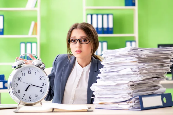 Jonge vrouwelijke werknemer zeer druk met lopende papierwerk in de tijd m — Stockfoto