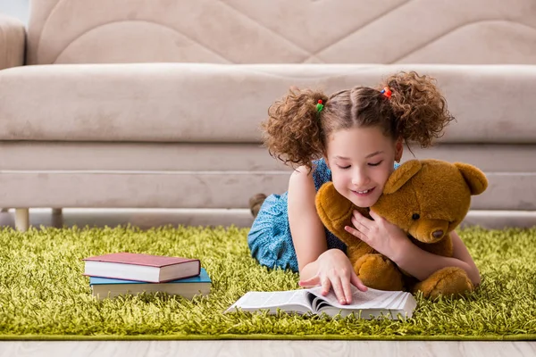 Klein mooi meisje die thuis boeken leest — Stockfoto