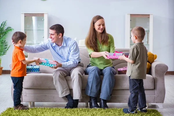 Padres jóvenes repartiendo regalos de Navidad en casa — Foto de Stock