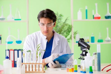 Genç biyoteknoloji bilim adamı kimyager laboratuarda çalışıyor.