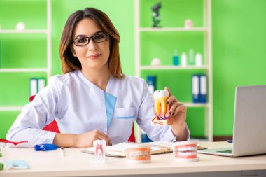 Diş implantı üzerinde çalışan kadın dişçi.