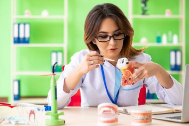 Diş implantı üzerinde çalışan kadın dişçi.