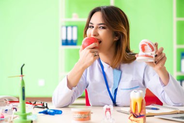 Diş implantı üzerinde çalışan kadın dişçi.