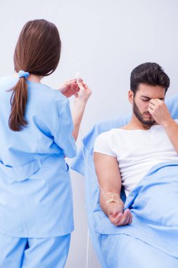 Kadın doktor erkek hastayı hastanede muayene ediyor.