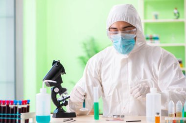 Laboratuvarda yeni bir deney üzerinde çalışan kimyager.