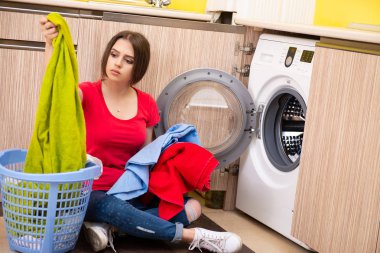 Evde çamaşır yıkayan bir kadın.