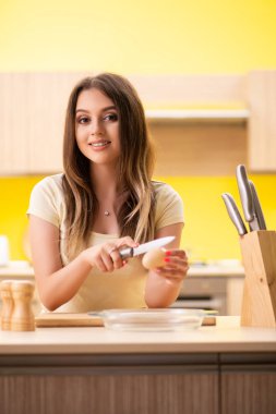 Genç bayan mutfakta salata hazırlıyor.