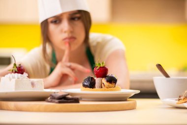 Genç aşçı mutfakta kek pişiriyor.