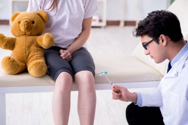 Doktor genç kızları çekiçle kontrol ediyor.