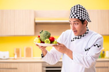 Genç profesyonel aşçı evde salata hazırlıyor.