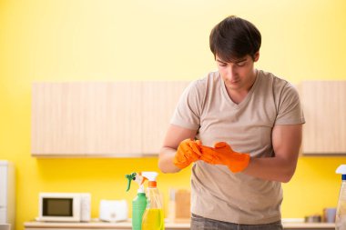 Bekar adam mutfağı temizliyor.