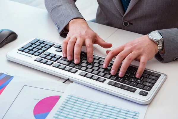 Finance professional working on keyboard with reports — Stock Photo, Image