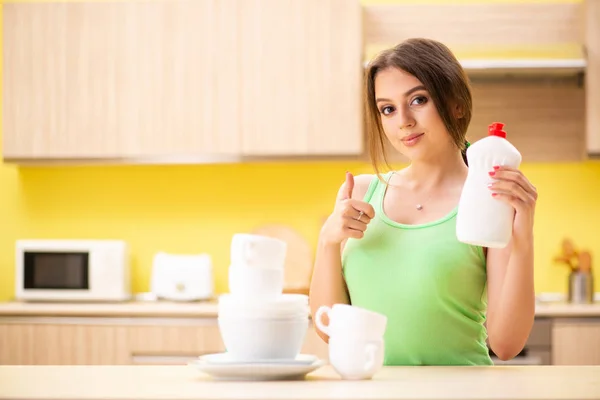 Mujer joven limpiando y lavando platos en la cocina —  Fotos de Stock