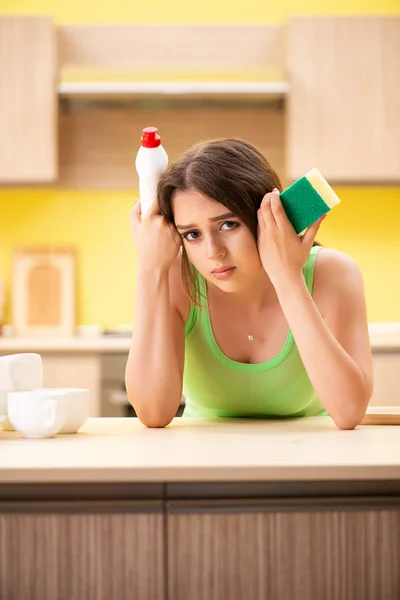 Mujer joven limpiando y lavando platos en la cocina — Foto de Stock