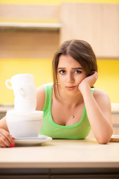 Wanita muda membersihkan dan mencuci piring di dapur — Stok Foto