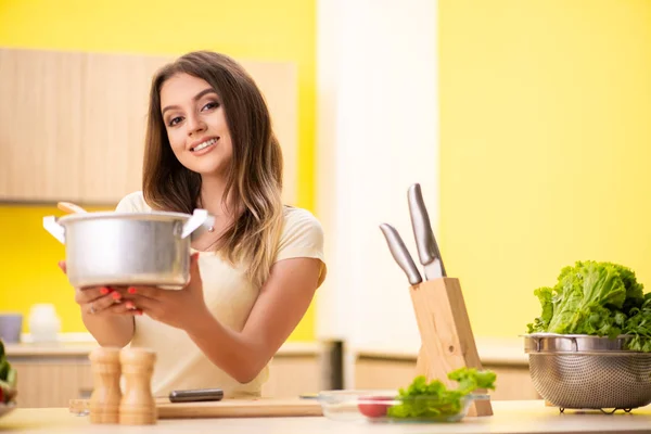 Młoda kobieta gotowanie zupy w kuchni w domu — Zdjęcie stockowe