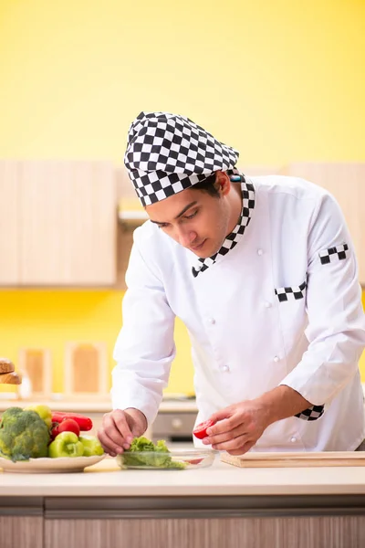 Joven cocinero profesional preparando ensalada en casa — Foto de Stock