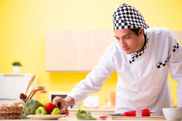 Young professional cook preparing salad at home — Stock Photo, Image