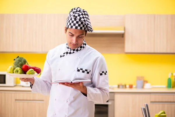 Young professional cook preparing salad at home — Stock Photo, Image