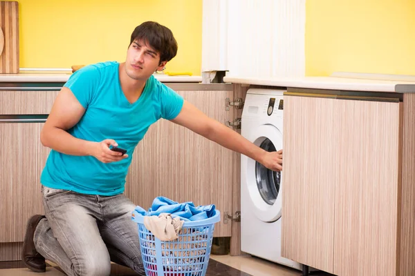 Jovem marido fazendo lavanderia em casa — Fotografia de Stock