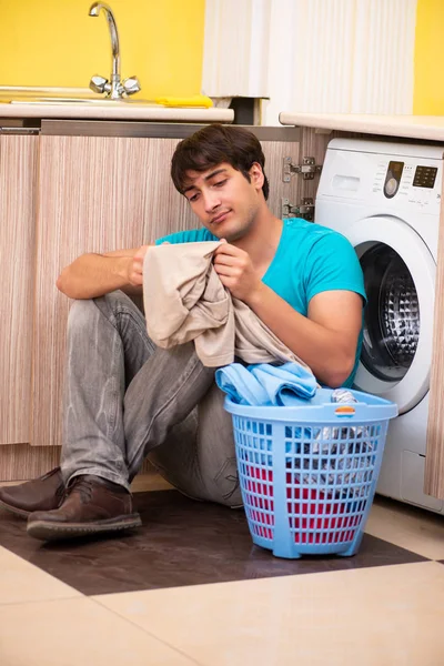 Joven marido hombre haciendo la colada en casa — Foto de Stock