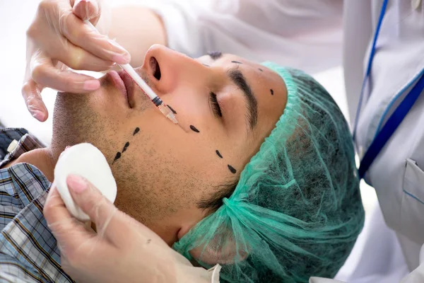 Plastic surgeon preparing for operation on man face — Stock Photo, Image