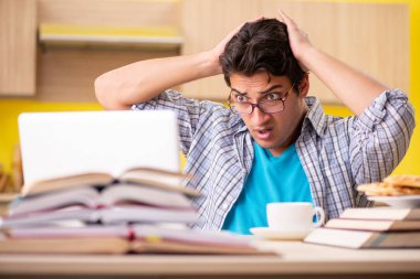 Sınava hazırlanan öğrenci mutfakta oturuyor. 