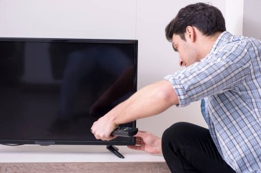 Bozuk televizyonu tamir etmeye çalışan adam