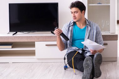 Bozuk televizyonu tamir etmeye çalışan adam