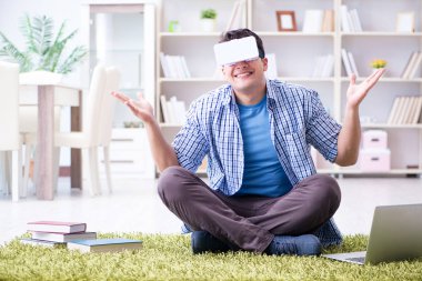Evde sanal gerçeklik gözlükleriyle serbest çalışan bir öğrenci.