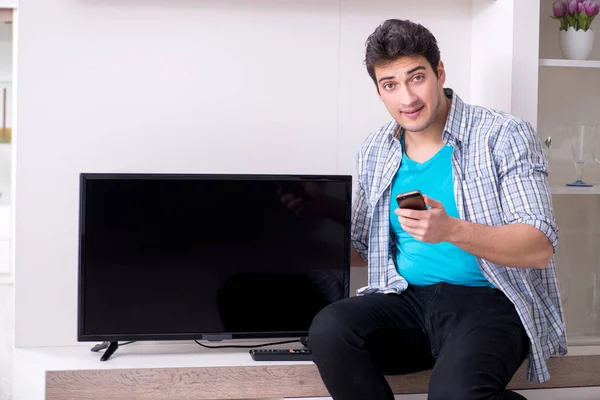 Hombre tratando de arreglar la televisión rota — Foto de Stock