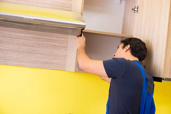 Jovem empreiteiro de serviços montagem de mobiliário de cozinha — Fotografia de Stock