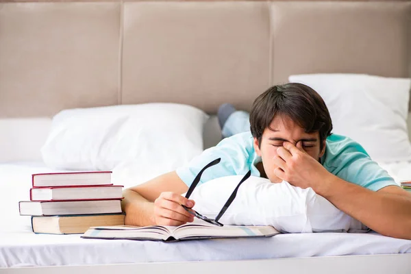Student preparing for exams at home in bedroom lying on the bed — Stock Photo, Image