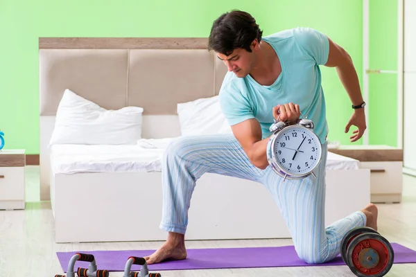 Young man in pajamas doing morning exercises