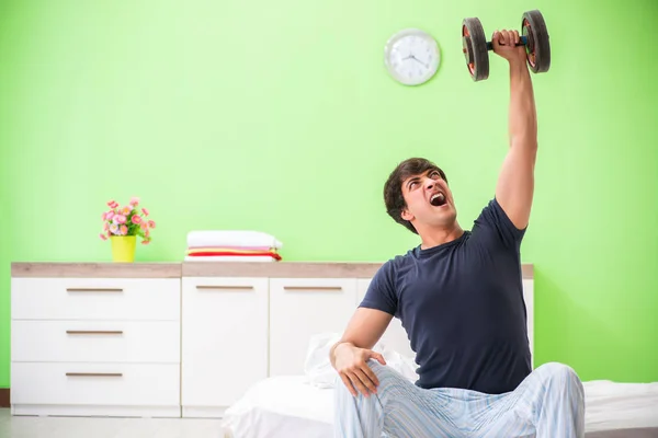 Young man in pajamas doing morning exercises