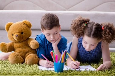 Kapıya resim çizen iki çocuk.