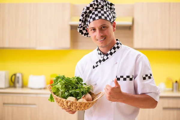 Jovem cozinheiro profissional preparando salada na cozinha — Fotografia de Stock