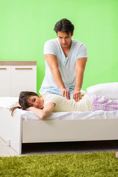 Mann tut Massage für seine Frau im Schlafzimmer — Stockfoto