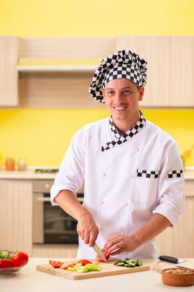 Young professional cook preparing salad at kitchen — Stock Photo, Image