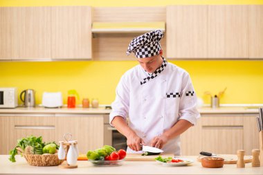 Genç profesyonel aşçı mutfakta salata hazırlıyor.